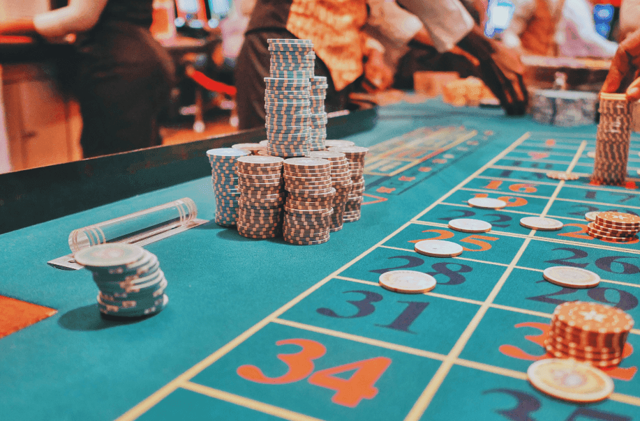 close-up shot of a green table in a casino, with stacks of poker chips placed on numbered squares.