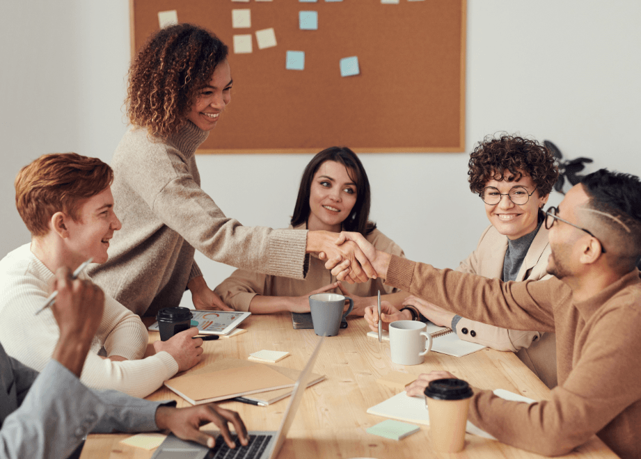 A group of men and women sitting around a table in the workplace.