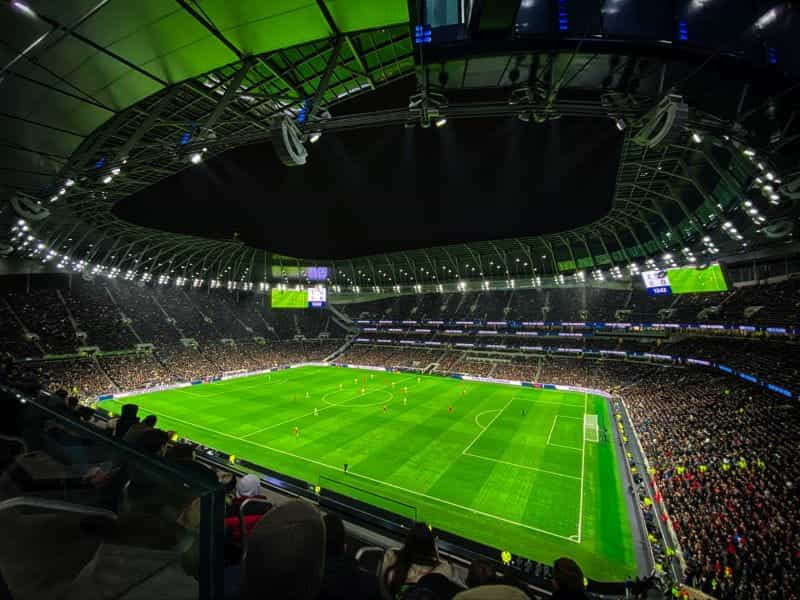 A green football pitch in a packed stadium.