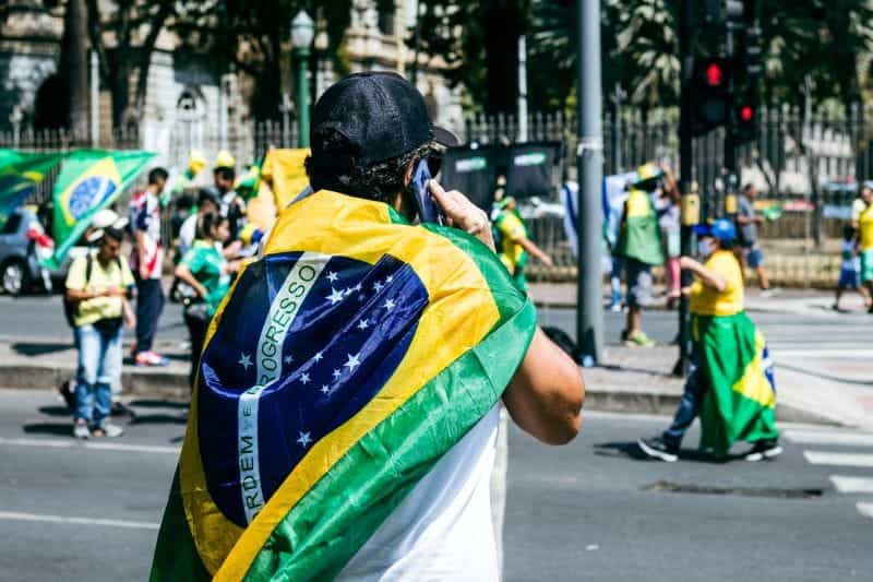 Protestors wear the Brazilian flag over their backs.