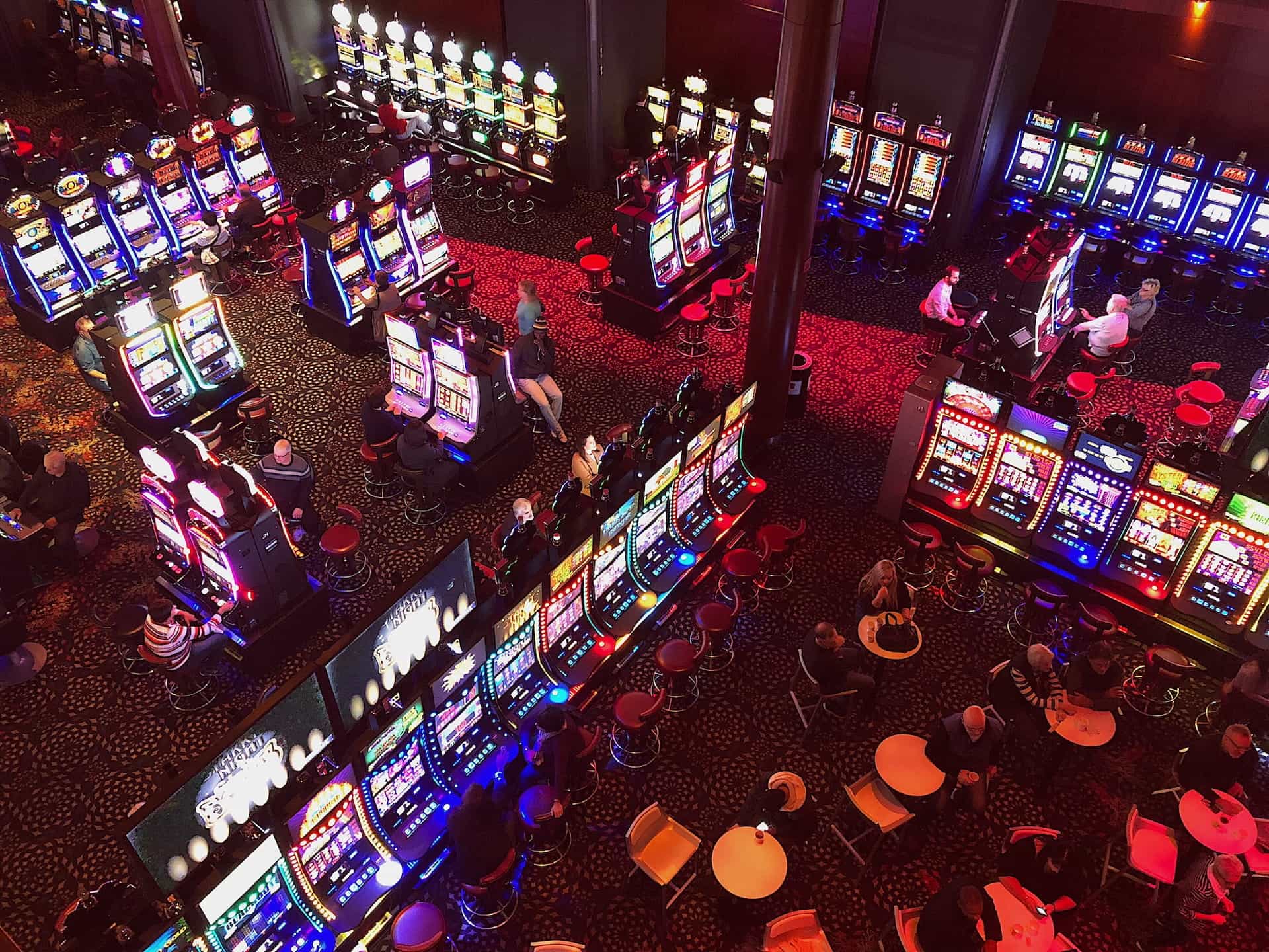 A shot from above of a large casino floor with many slot machines.